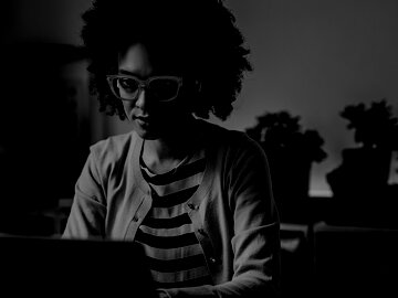 Woman wearing glasses working on her laptop