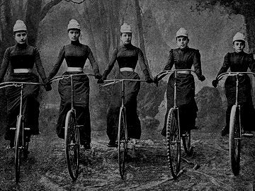 Identical victorian women riding a bike